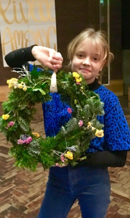 Girl holding handmade Christmas wreath